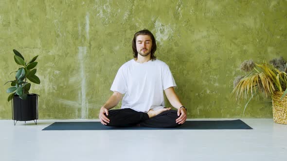 Calm Man Sitting on Yoga Mat in Lotus Pose