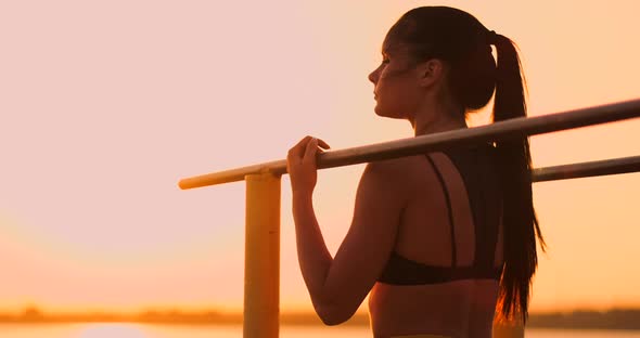 Woman Resting While Standing in the Sunset Bar Near the Rear View