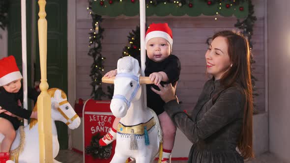 Babies Sitting on Christmas Carousel