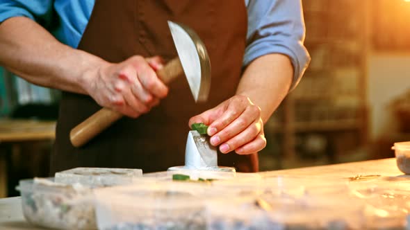 Working man with a hammer in creative workshop