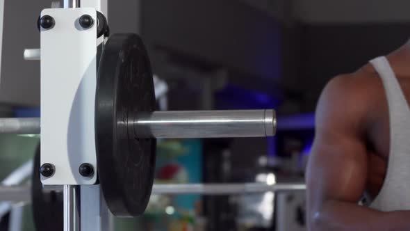 African Man Putting Weight Plates on Barbell Exercising at the Gym