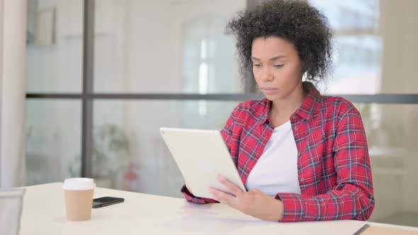 African Woman Using Tablet While Sitting