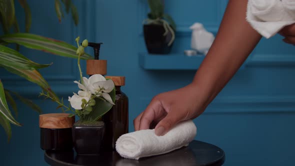 Closeup of Woman Hand Putting Small White Towels on Table Indoors