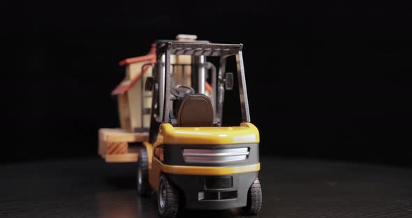 Forklift Truck Holds a House on a Pallet