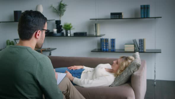 Patient meditating on a couch in a psychotherapist's office / Videohive