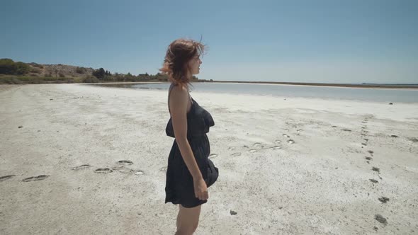 Beautiful Redhaired Woman Walks and Has a Good Time on a Dry Salt Lake in France