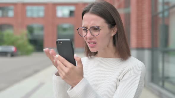 Young Woman Reacting to Loss on on Smartphone