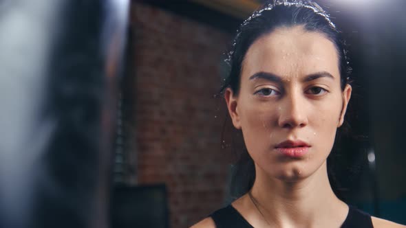 Portrait of Asian Lady Mma Fighter with Drops of Sweat on Skin Posing at Dark Gym