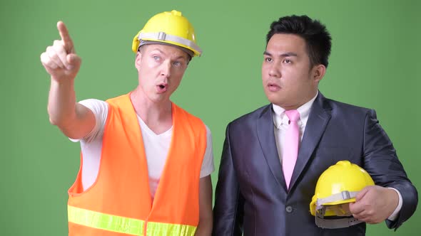 Scandinavian Man Construction Worker and Asian Businessman Working Together