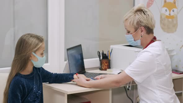 Woman Doctor Pediatrician Talking To Kid Girl Patient at Medical Checkup