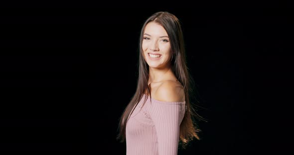 Portrait of a Young Beautiful Woman Wearing Pink Dress Turning Around Smiles and Looking at you She