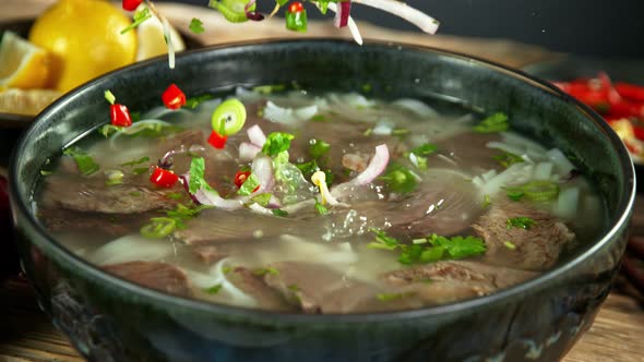 Super Slow Motion Detail Shot of Ingredients Falling Into Beef Pho Soup at 1000 Fps