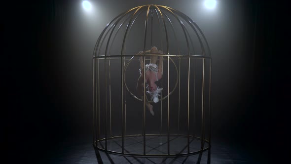 Girl in a Twine Upside Down Spinning on a Hoop in a Cage