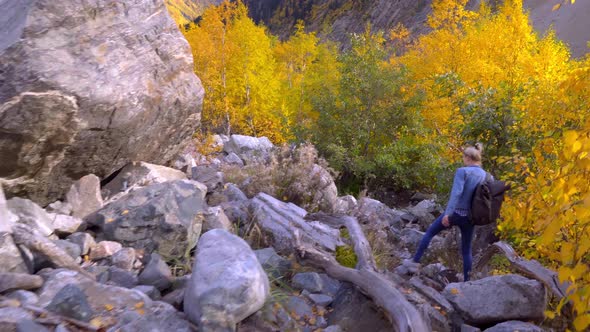 A young beautiful slender woman alone in the mountains.