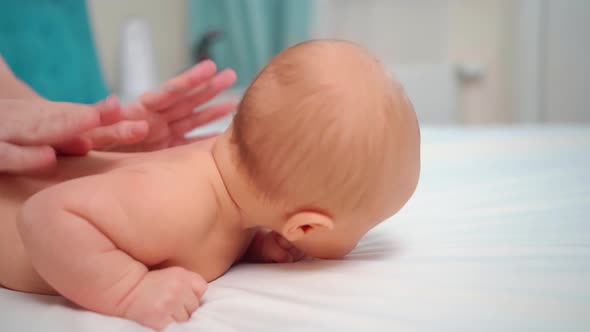 the Baby Lies on His Tummy on a White Sheet