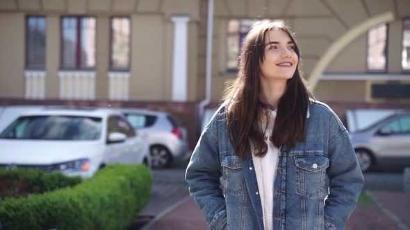 Smiling brunette enjoys the city, looking at the beautiful street