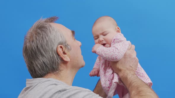 Funny Game and Laugh of Caucasian Old Man and Baby Girl in Domestic Comfort