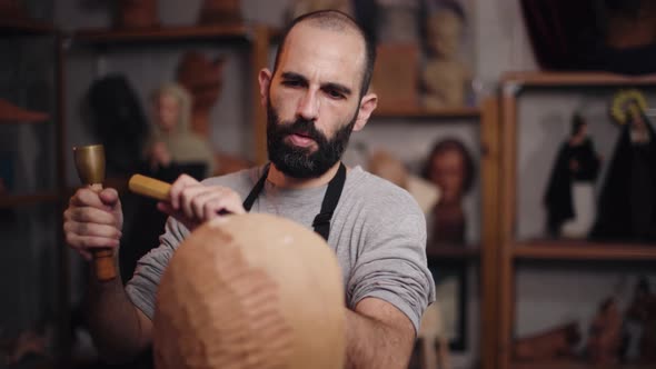 Focused craftsman shaping wooden detail with chisel