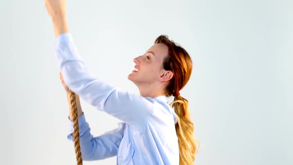 Woman pulling a rope against white background