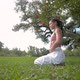 Side View of Young Woman Practicing Breath exercise Under a Tree in a Park.Yoga Outdoor - VideoHive Item for Sale