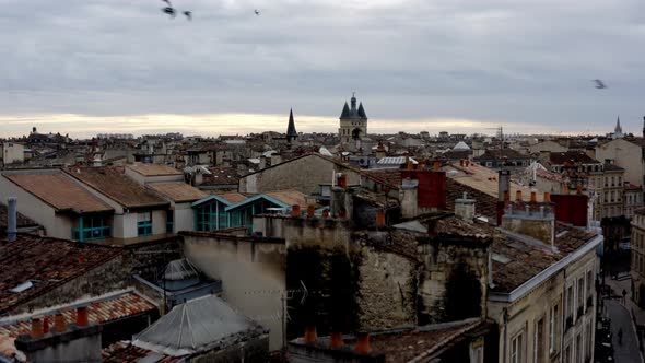 City of Bordeaux with Grosse Cloche Big Bell in the distance with pigeons flying in front, France, A