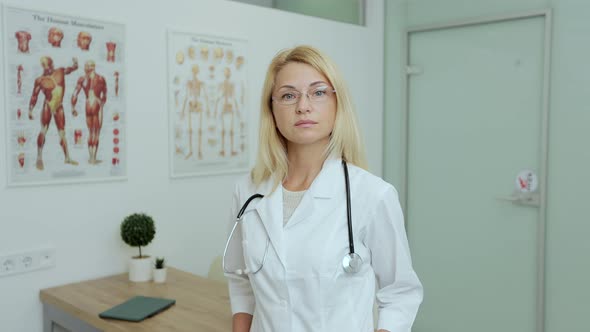 Portrait of Smiling Female Doctor with Glasses Satisfied with Her Job in a Medical Office
