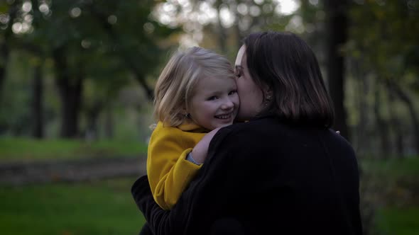 Happy Time, Sensitive Mother Carefully Plays with Her Charming Daughter in Meadow in Autumn Park