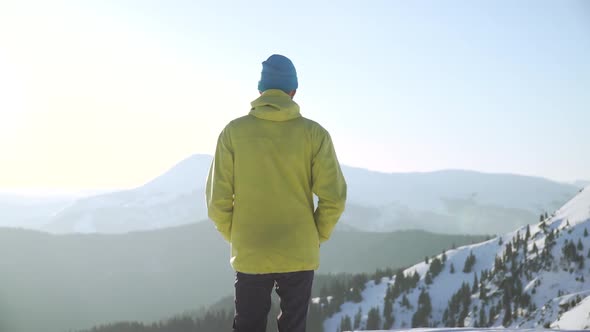 Crane Shot of Man Hiker Walking on Snow Towards Mountains at Sunrise