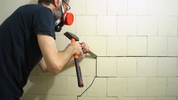 Bearded Middleaged Worker in Respirator and Protective Glasses with Tools Dismantles an Old White