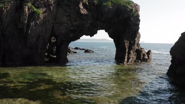 Flying a Drone Through a Natural Stone Arch on the Seashore