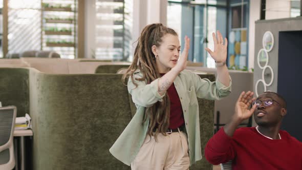 Young Woman Giving High-Fives to Colleagues in Office