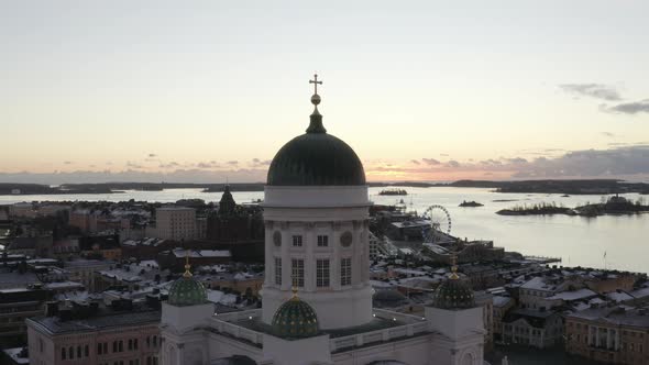 Drone aerial view of Helsinki Cathedral with the sea and sunset on the background.