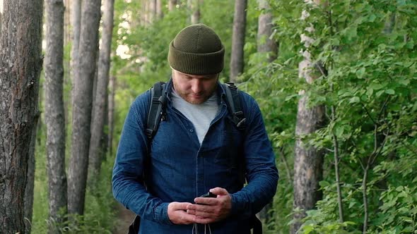 Disabled man uses compass to navigate traveling along forest paths.