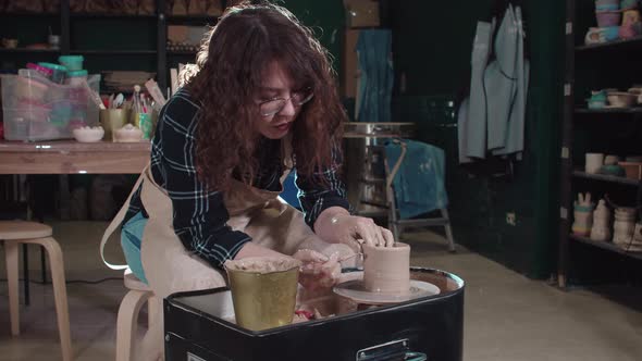 Pottery Crafting  Woman Working with a Clay and Cutting Off the Top Piece with a Stick