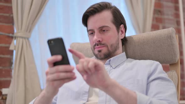 Portrait of Casual Young Man Using Smartphone