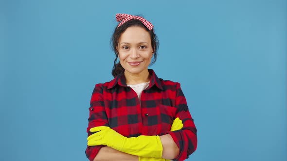 Studio Portrait of Confident Housewife in Protective Gloves Posing with Folded Arms and Laughing to