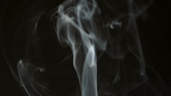 Smoke from a cigarette on a black background.