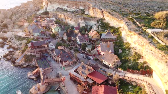 Wooden film set village of Popeye on Malta island coastline, aerial drone view