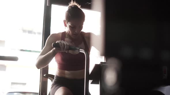 Woman Working Out at the Strength Bike on Sports Club in Slow Motion