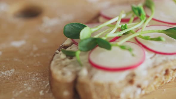 Open-faced sandwich mascarpone cheese, radish microgreens. cooking sandwich with healthy ingredient