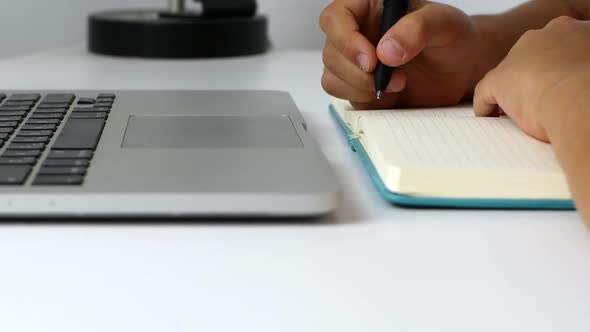 A child girl on distance learning sits in front of a laptop and does homework. Distance learning