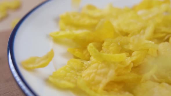 Cooking cornflakes falling into a plate.