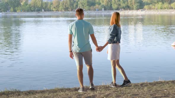 Young teenage couple walking holding hands and having fun outdoors.