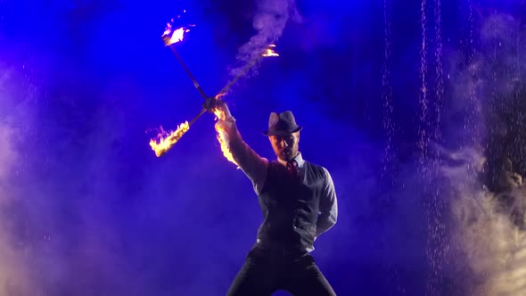 An Enchanting Show of Fire in Rain and Water Drops Performed By a Stylish Man. Smoky Studio