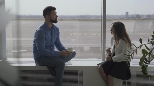 Adult Caucasian Man and Little Girl Sitting at the Airport Windowsill and Talking