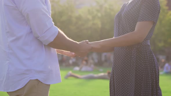 Cropped Shot of Multiethnic Couple Holding Hands in Summer Park