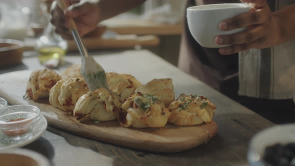 Brushing Garlic Butter Atop Freshly Baked Buns