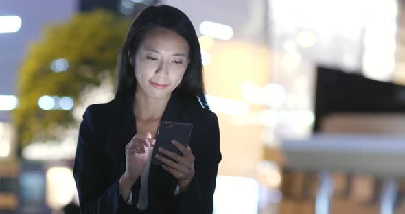 Woman Looking at Mobile Phone in City 