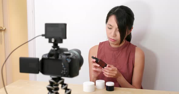 Woman taking video for beauty product at home