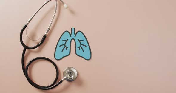 Video of close up of stethoscope with lungs on pink background